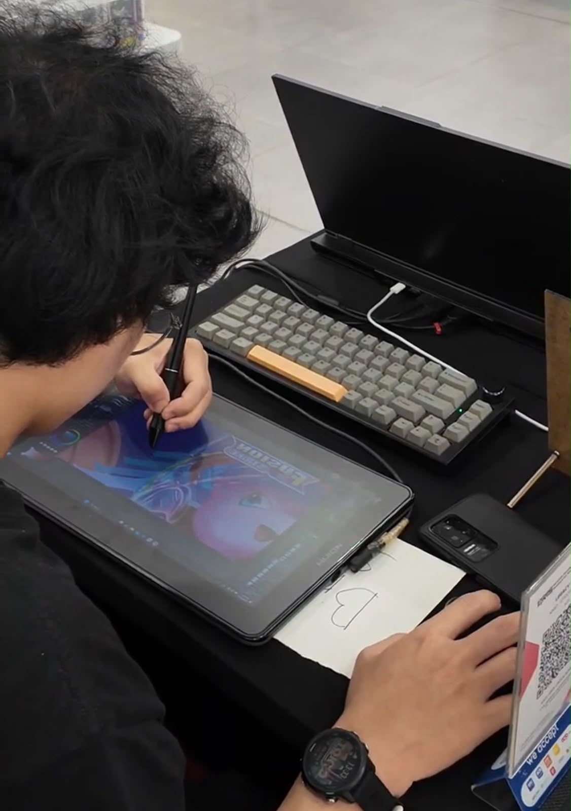 Close-up of an illustrator extending card artwork stroke by stroke